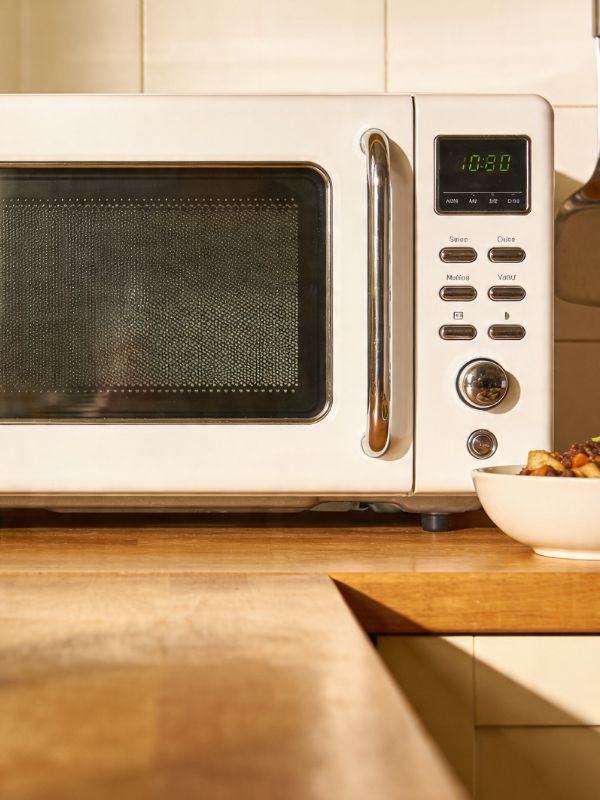 Technician performing an over-the-range microwave repair — no-heat and magnetron diagnostics in a Round Rock, TX kitchen